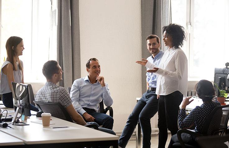 A woman engages her team in conversation.