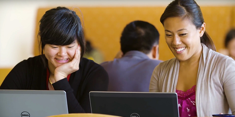 Two happy Illumina employees working together.
